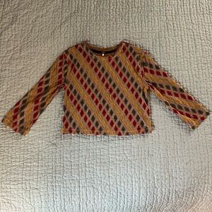 Long sleeved tan crop top with red, green and yellow textured diamond design.
